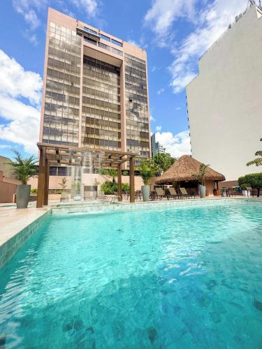 a swimming pool in front of a tall building at Castro's Park Hotel in Goiânia