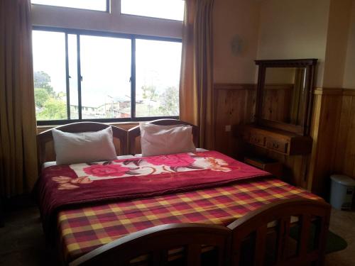 a bedroom with a bed with flowers on it at Highcliffe Guest House in Haputale