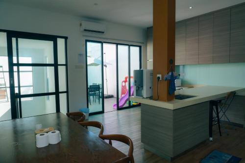 a kitchen with a table and a counter with chairs at Bandar Botanic Klang lux bungalow Home stay in Pelabohan Klang