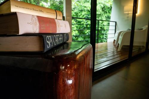 a stack of books sitting on top of a table at Jungle Bungalow at Oropel Lodge in Puerto Viejo