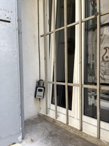 une fenêtre sur un bâtiment avec un téléphone payant à côté de celui-ci dans l'établissement Studio équipé confort proche de toutes commodités, à La Seyne-sur-Mer