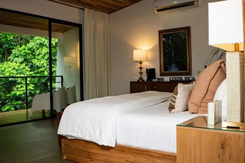 a bedroom with a large bed and a balcony at Jungle Bungalow at Oropel Lodge in Puerto Viejo