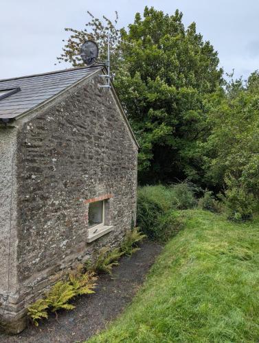 an old brick building with a window on the side of it at Herdsmans Cottage in Slane