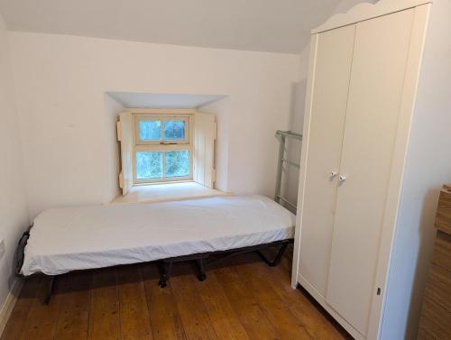 a small bedroom with a bed and a window at Herdsmans Cottage in Slane