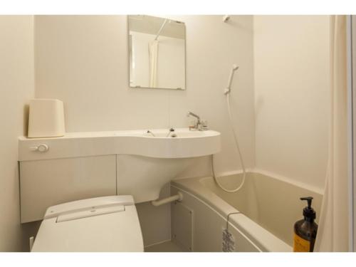 a bathroom with a sink and a toilet and a mirror at Condominium Resort Naha Living Inn Asahibashiekima - Vacation STAY 92450v in Naha
