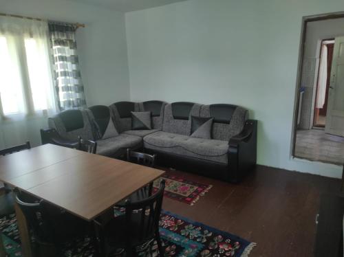 a living room with a couch and a table at Complex de pensiuni si casute -Hangu , Bicaz in Buhalniţa