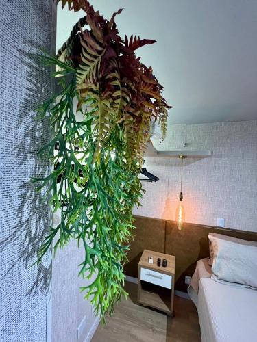a plant hanging from a wall in a bedroom at View 462 Só para você! in Brasilia
