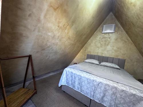 a bedroom with a bed in a attic at Chalé com ventilador in Itacaré