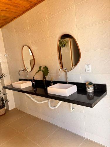a bathroom with two sinks and two mirrors at Chalé 1 in Itacaré