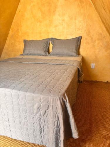 a bed with two pillows in a room at Chalé 1 in Itacaré