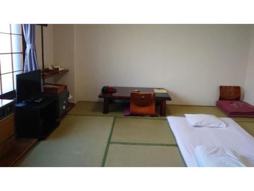 冨浦にあるKojohama Onsen Hotel Izumi - Vacation STAY 93850vのベッドとテレビとテーブルのある部屋
