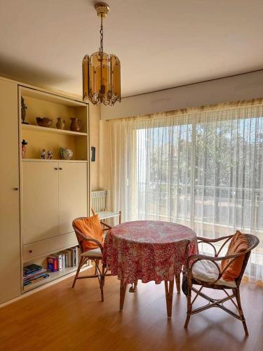 une salle à manger avec une table et des chaises et une fenêtre dans l'établissement Résidence Caravelle - Arcachon Pereire - Studio avec accès direct à la plage MAE-8344, à Arcachon