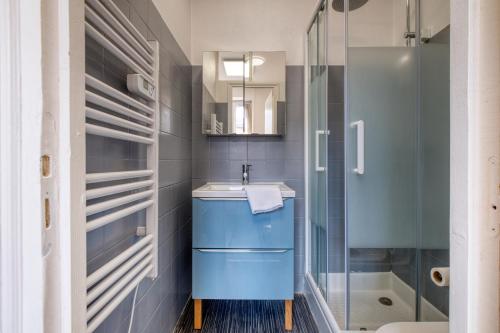 une salle de bain avec un lavabo bleu et une douche dans l'établissement Le deuxième ciel de la vertu, à Périgueux