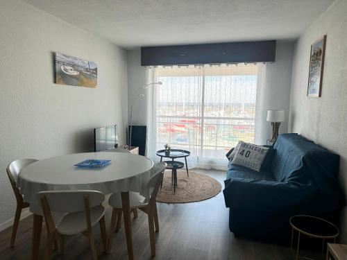 un salon avec une table et un canapé dans l'établissement Résidence Pieds Dans L Eau - T2 tout confort avec vue bassin – 4 personnes MAE-0204, à Arcachon