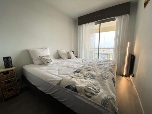une chambre avec un grand lit avec une fenêtre dans l'établissement Résidence Pieds Dans L Eau - T2 tout confort avec vue bassin – 4 personnes MAE-0204, à Arcachon