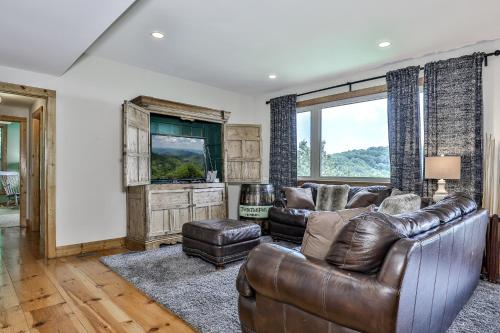 a living room with leather furniture and a large window at Southern Views in Jasper