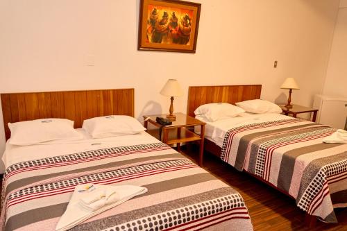 a hotel room with two beds and a picture on the wall at Hotel Pacífico Talara in Talara