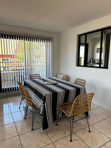 - une salle à manger avec une table, des chaises et un miroir dans l'établissement Résidence Louisiane - Arcachon: T3 moderne à deux pas de la plage MAE-5221, à Arcachon