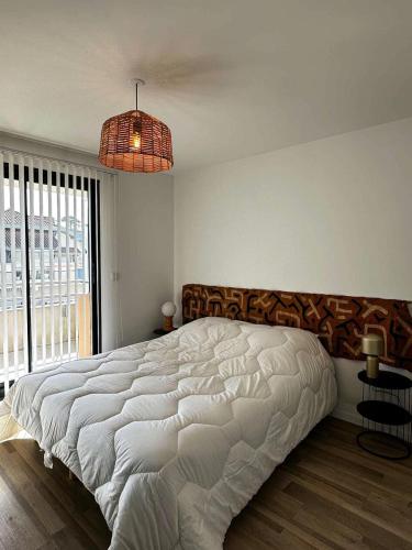 une chambre avec un grand lit et une grande fenêtre dans l'établissement Résidence Louisiane - Arcachon: T3 moderne à deux pas de la plage MAE-5221, à Arcachon
