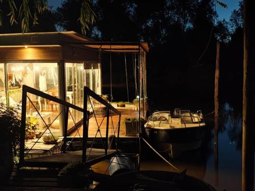 a boat is docked in the water at night at Casa Flotante Nenufar in Tigre