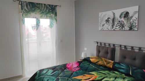 a bedroom with a bed with a colorful blanket at Bed and Breakfast Oasi in Reggio Calabria