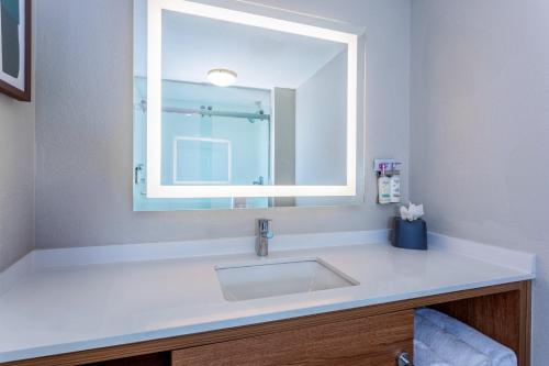 a bathroom with a sink and a mirror at Holiday Inn Hotel & Suites Daytona Beach On The Ocean by IHG in Daytona Beach