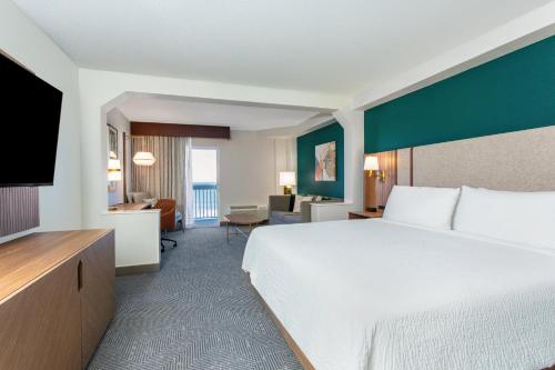 a hotel room with a bed and a living room at Holiday Inn Hotel & Suites Daytona Beach On The Ocean by IHG in Daytona Beach