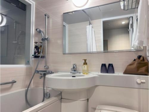 une salle de bain blanche avec lavabo et douche dans l'établissement Garden Hotel Shizuoka - Vacation STAY 45848v, à Shizuoka