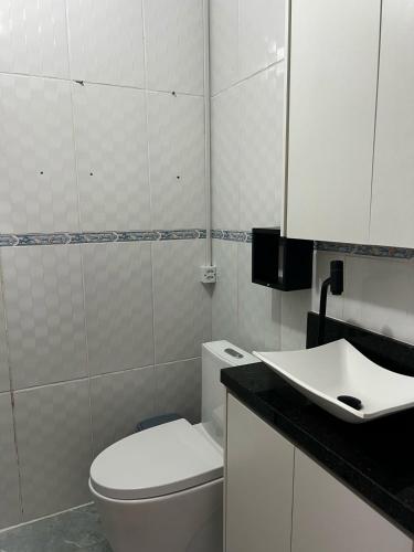 a bathroom with a white toilet and a sink at Apartamento próximo ao Aeroporto de Floripa in Florianópolis