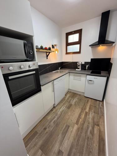 a kitchen with white cabinets and a stove top oven at MonnaLisa in Périgueux