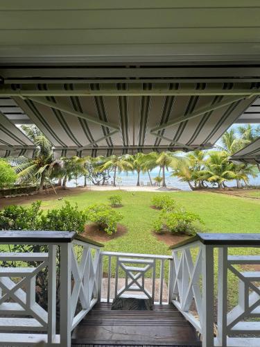 a porch with a view of a park at Fare Mama Rota - au bord de l'océan in Taputapuapea