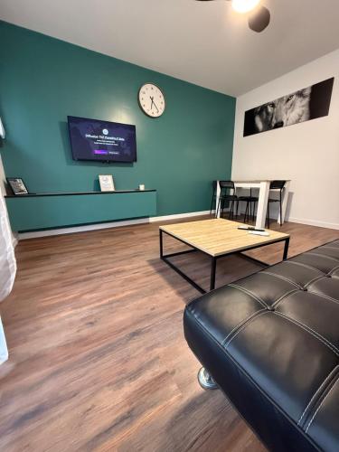 a living room with a couch and a clock on the wall at MonnaLisa in Périgueux