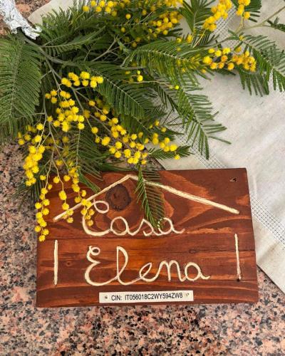 a wooden sign sitting on top of a table with flowers at Casa Elena in Castiglione in Teverina