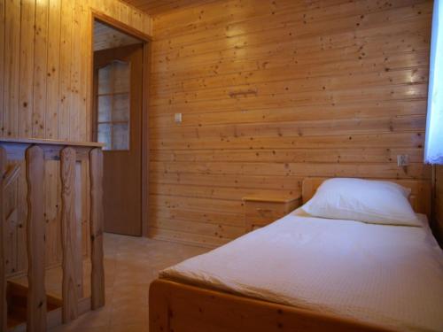 a bedroom with a bed in a wooden room at Terraced House in Rewal near Baltic Sea Beach in Rewal