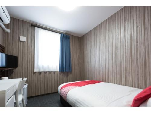 石巻市にあるHotel M&K Ishinomaki - Vacation STAY 54483vのベッドと机と窓のある寝室