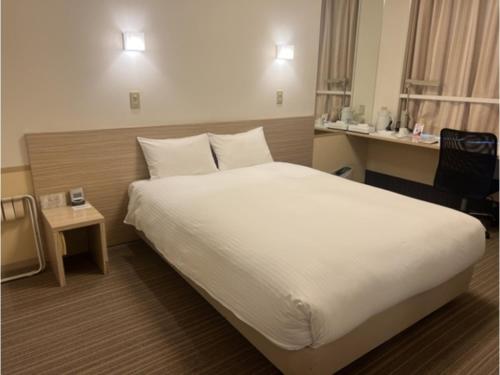 una camera d'albergo con un grande letto con lenzuola bianche di Smile Hotel Shirakawa - Vacation STAY 54762v a Nishigo