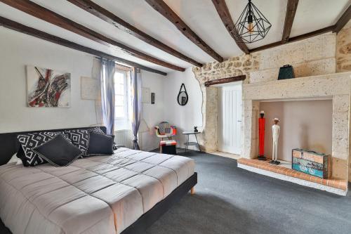 - une chambre avec un grand lit et une cheminée dans l'établissement Raisin et Toile - French American Retreat, à La Rochebeaucourt-et-Argentine