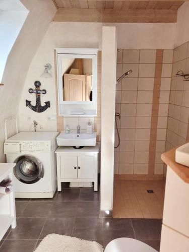 a bathroom with a sink and a mirror at Ferienhaus ROSA mit Sauna in Dorum-Neufeld
