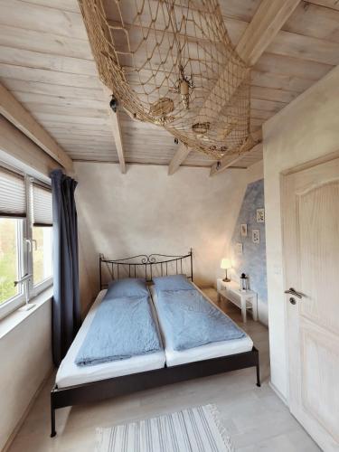 a bedroom with a bed and a wooden ceiling at Ferienhaus ROSA mit Sauna in Dorum-Neufeld
