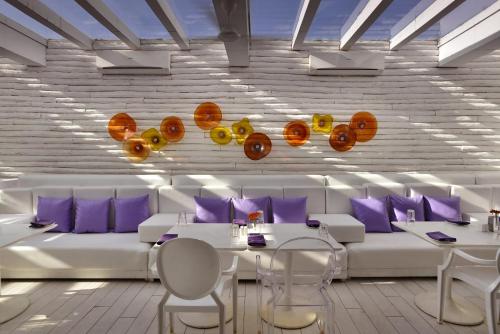 a dining room with white furniture and purple pillows at The Park Calangute Goa in Calangute