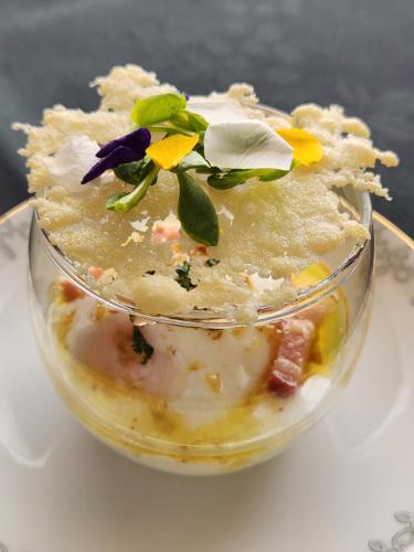 a glass bowl filled with food on a plate at Pension Green Lake in Gujo