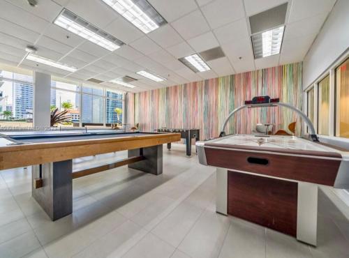 a large room with two sinks and a pool table at Brickell Center w/City & Bay View + FREE Parking! in Miami