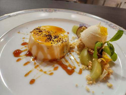 a white plate with a dessert on a table at Pension Green Lake in Gujo