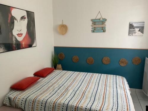 une chambre avec un lit et un tableau au mur dans l'établissement maison landes, à Tarnos