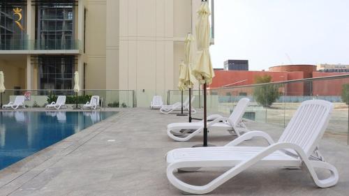 Bazén v ubytování Greywood Oasis 2BR Elegant Retreat Near Masdar Park & City Centre Masdar nebo v jeho okolí