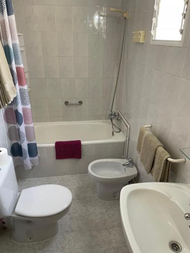 a bathroom with a toilet and a tub and a sink at Hotel Madrid in Santiago de la Ribera