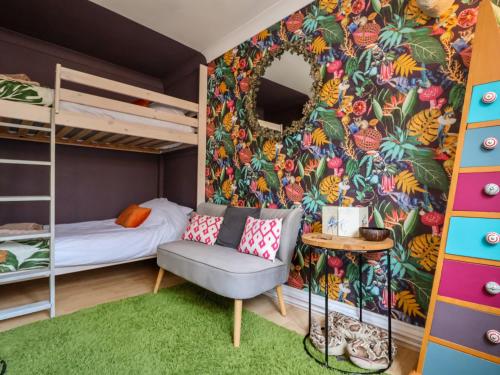a bedroom with bunk beds and a couch and a chair at The Corner House in Woodbridge