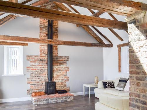 a living room with a brick wall and a fireplace at Christine Cottage in Flamborough