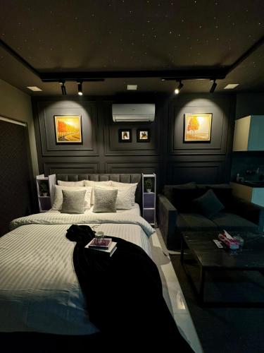 a bedroom with a large bed and a couch at Starlit By Zameen Opal in Lahore