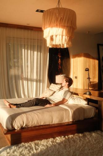 a man laying on a bed in a bedroom at Cuna del Cielo in San Miguel de Allende
